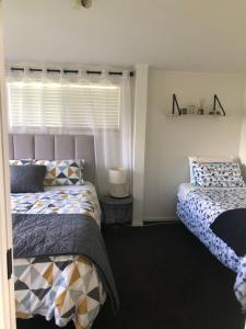 玛塔玛塔Hills Vista Lodge的一间卧室设有两张床和窗户。