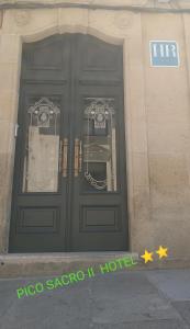 圣地亚哥－德孔波斯特拉PICO SACRO II HOTEL Santiago de Compostela的建筑物上一对门,有标志