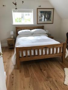 OvingtonLane End Cottage的卧室内的一张大床,铺有木地板