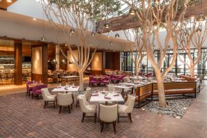 蒙特雷波托拉Spa酒店的一间设有桌椅和树木的餐厅