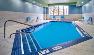 温莎温莎海滨快捷假日酒店的游泳池位于酒店房间,周围设有椅子