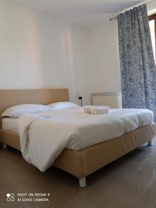 巴多利诺BETULLA BIANCA的一间卧室配有一张带蓝色窗帘的大床