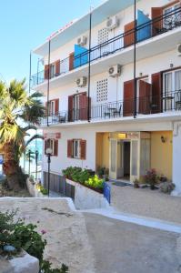 阿吉亚玛丽娜Oasis Hotel Theodoros & Litsa Galaris的带阳台的大型白色建筑和棕榈树