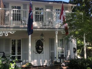 滨湖尼亚加拉Harrogate House Inn的前面有两面旗帜的白色房子