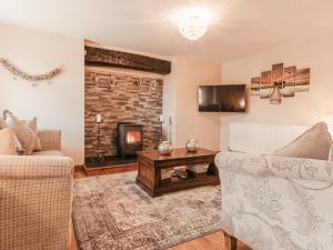 兰贝德Cefn Uchaf Cottage的客厅配有两把椅子和壁炉