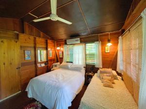 尼格瑞尔朱迪小屋和客房度假屋的一间卧室配有一张床和吊扇
