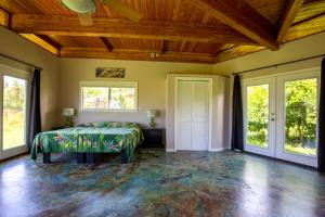 帕霍阿Kalani Oceanside Retreat的一间卧室设有一张床和木制天花板