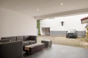 伦邦Lembang Views的客厅配有沙发,车库内有一辆汽车