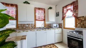 East End VillageMoonlight Cottage的厨房配有白色橱柜和炉灶。