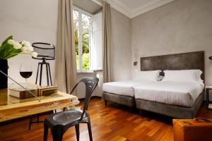 罗马圣彼得精品客房旅馆的一间卧室配有一张床、一张桌子和一把椅子