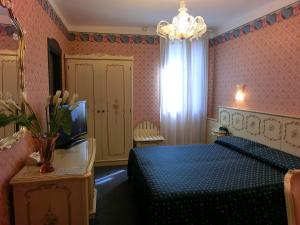 威尼斯戴安娜酒店的一间卧室配有蓝色的床和电视