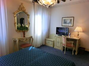 威尼斯戴安娜酒店的一间卧室配有一张床、镜子和电视