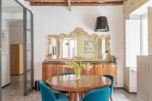 罗马iFlat Vatican High-End Apartment的一间带木桌和蓝色椅子的用餐室