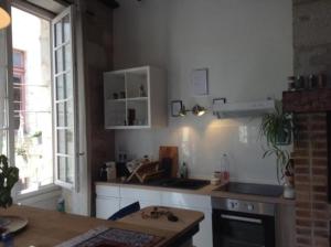 佩里格appartement coeur historique的厨房配有白色橱柜和台面