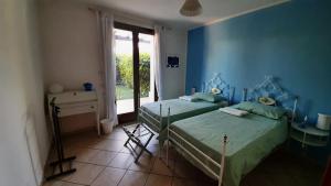 米萨诺阿德里亚蒂科La Casa Azzurra的蓝色的客房设有两张床和窗户。