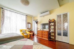 花莲市白色棉花糖民宿的一间卧室配有一张床、梳妆台和电视。