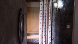 纳库鲁麦莉沙巴山林小屋的一间设有窗帘和一张带窗户的床的房间