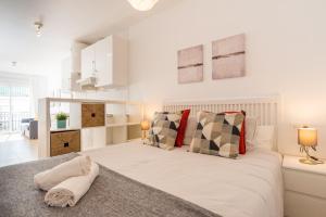 贝纳尔马德纳Modern studio apartments Benalmadena的白色卧室配有带枕头的大床