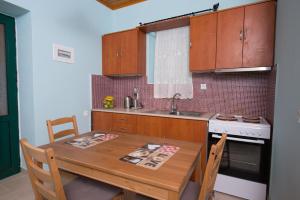 LazarátaΠέτρινο σπίτι的厨房配有木桌、水槽和炉灶。