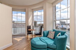 阿伯丁Victoria Court Suites - Aberdeen的客厅设有蓝色的沙发和大窗户