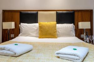 阿伯丁Victoria Court Suites - Aberdeen的一间卧室配有一张床,上面有两条毛巾