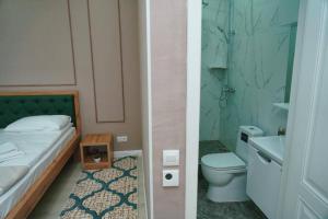 阿拉木图Halal Apart Hotel Almaty的浴室设有床、卫生间和水槽。