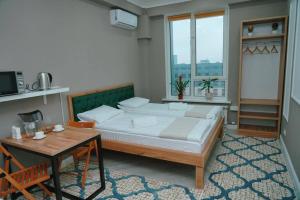 阿拉木图Halal Apart Hotel Almaty的一间卧室配有一张大床和一张桌子