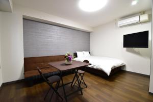 冈山Regariain - Vacation STAY 85013的一间卧室配有一张床和一张鲜花桌子