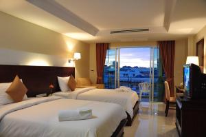 芭堤雅市中心八月套房酒店的酒店客房设有两张床和电视。