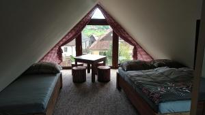 鲁容贝罗克Privat LeNa的一间卧室配有一张床、一张桌子和一个窗户。