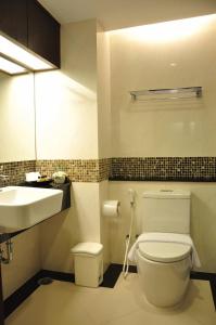 芭堤雅市中心八月套房酒店的浴室配有白色卫生间和盥洗盆。