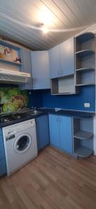 陶格夫匹尔斯Vienibas 38a的厨房配有洗衣机和蓝色橱柜。