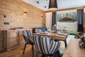 里约·迪·普斯特里亚App Mulin Rudl mit Sauna的用餐室设有木墙和桌椅