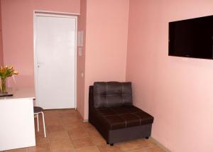 叶卡捷琳堡Aparts Leto的一间房间,墙上有椅子和电视