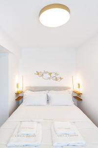 林都斯Villa Dafni - Lindos的卧室配有白色床和2个白色枕头
