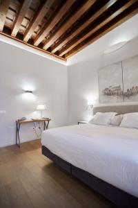 托莱多Hospedium Hotel Posada de la Silleria的白色卧室配有一张大床和一张书桌
