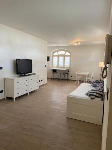 福萨诺Coronata 22的一间卧室配有一张床、一台电视和一张桌子
