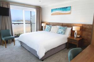 纽基访问不列颠3星银奖滨海酒店的一间卧室设有一张床,享有海景