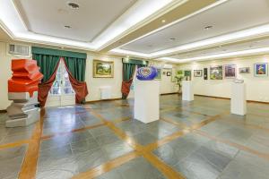格拉玛多Tri Hotel Le Chateau的大房间装饰有绘画和艺术作品