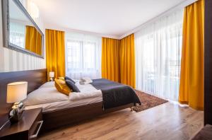 米泽德沃兹Delfin的一间卧室配有一张带黄色窗帘的大床