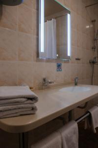 图阿普谢Astoria Hotel的浴室配有盥洗盆、镜子和毛巾