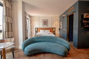 科克The Dean Cork的一间卧室配有一张床和一张蓝色的大沙发