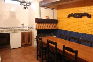 萨马涅戈SagastiEnea Villa con Piscina y Tenis en la Rioja的厨房配有木桌、椅子和炉灶。