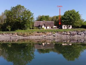 戈尔韦The Cosy Cabin by the shore的湖边的房子,有红箭标着谷物