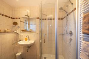 施塔费尔湖畔穆尔瑙Boutique Hotel Angerer的带淋浴和盥洗盆的浴室