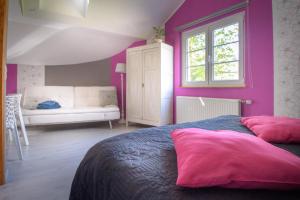 雅莱雷吉纳住宿加早餐旅馆的一间卧室设有紫色的墙壁和一张带粉红色枕头的床