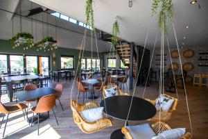 代讷坎普Papillon Country Resort的餐厅设有桌椅和窗户。