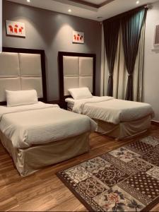 Qarārشاليهات شاطئ ارينا的一间带两张床的卧室和地毯