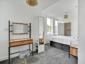 曼彻斯特Albert View Rooms的一间卧室配有一张床、一张书桌和一面镜子