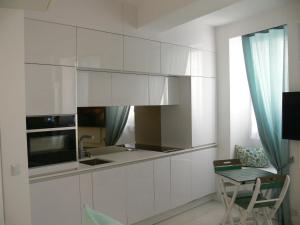 圣特罗佩Stone studio的厨房配有白色橱柜和桌子